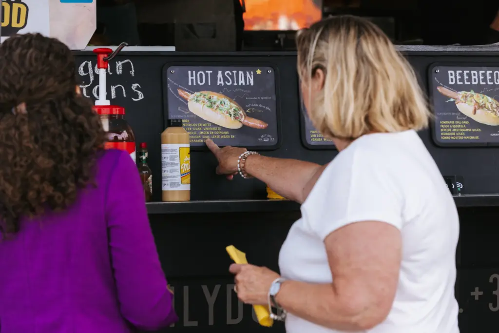 Vrouw kiest een hotdog bij een foodtruck
