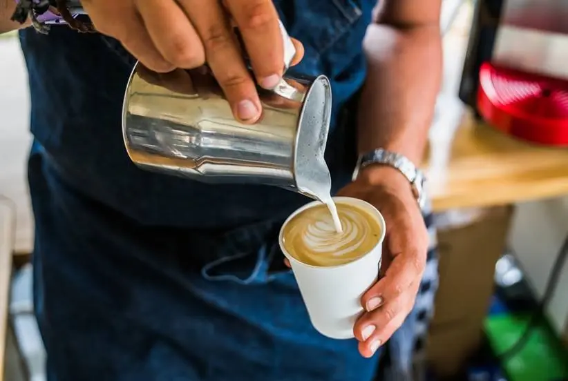 Cappuccino met latte art wordt bereidt door barista