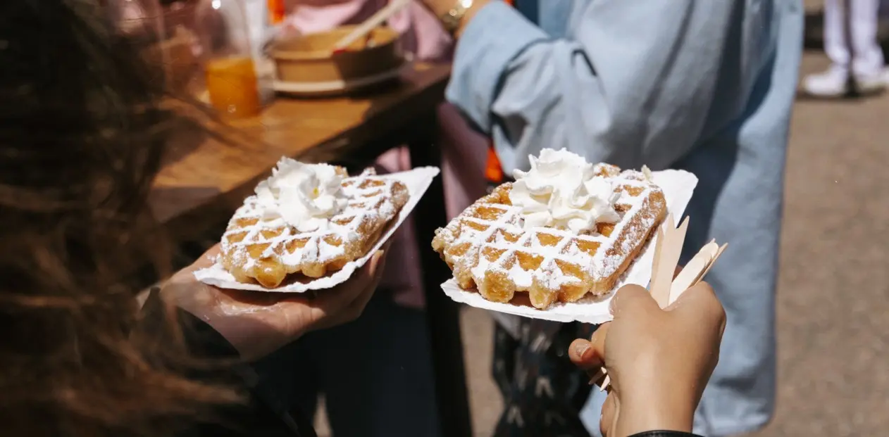Twee verse wafels met poedersuiker en slagroom