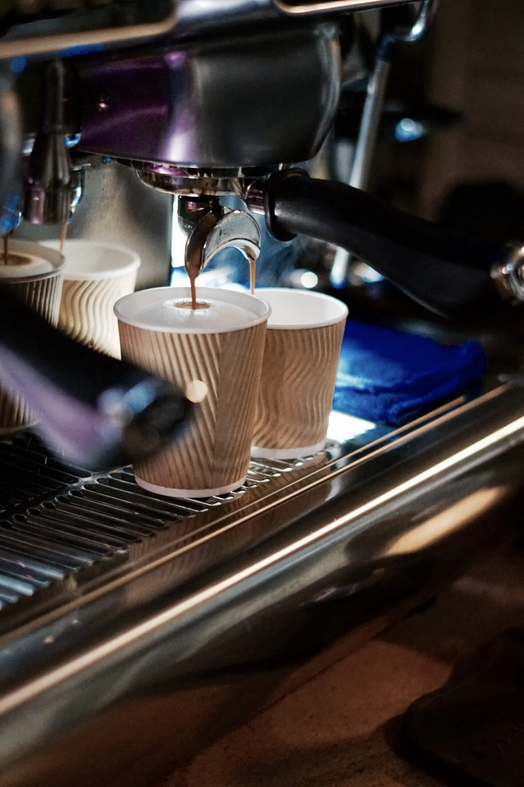 Espresso loopt uit de machine in twee kartonnen bekers