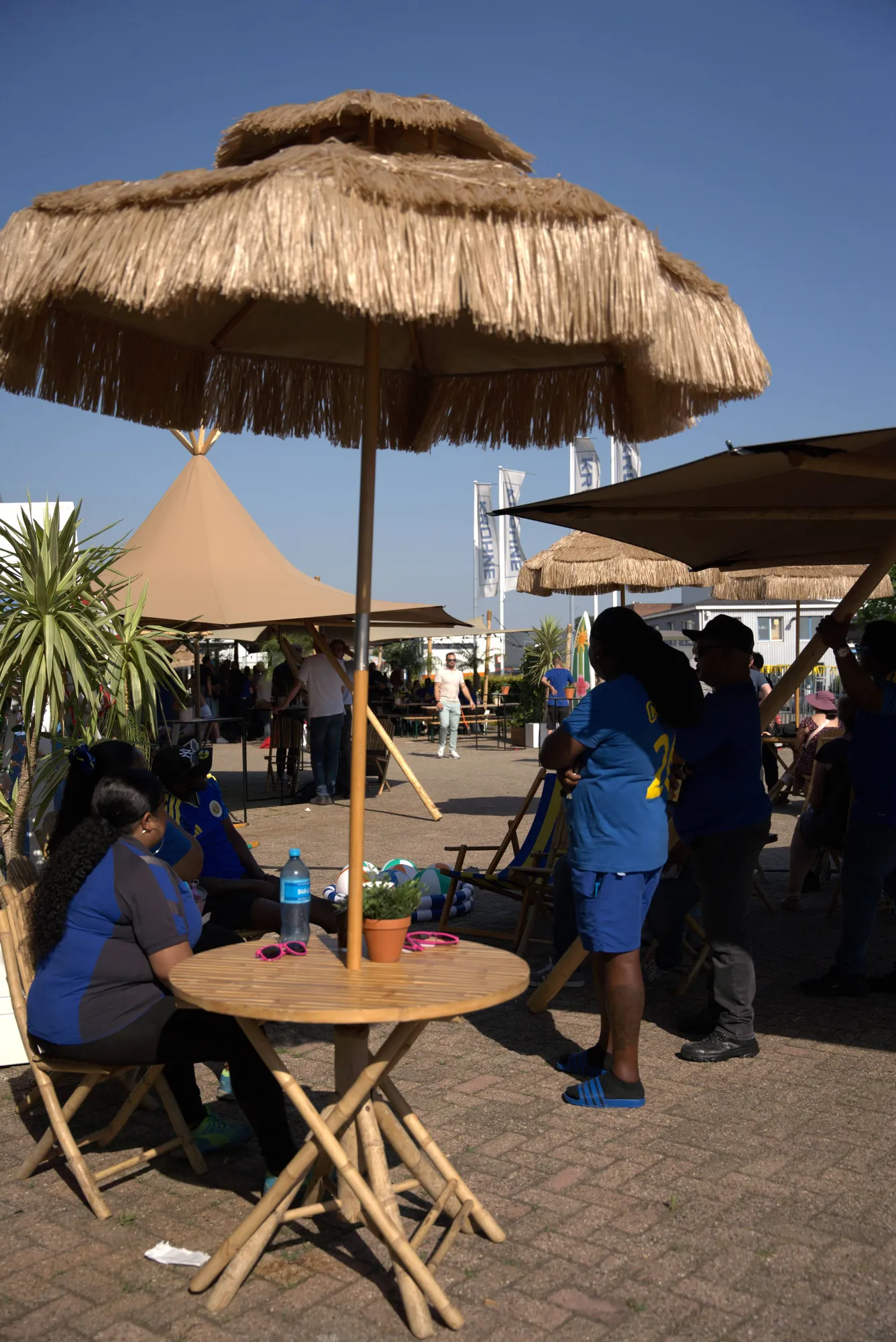 Rieten parasols en bamboe statafels op een zonnig terrein tijdens een zomers foodfestival
