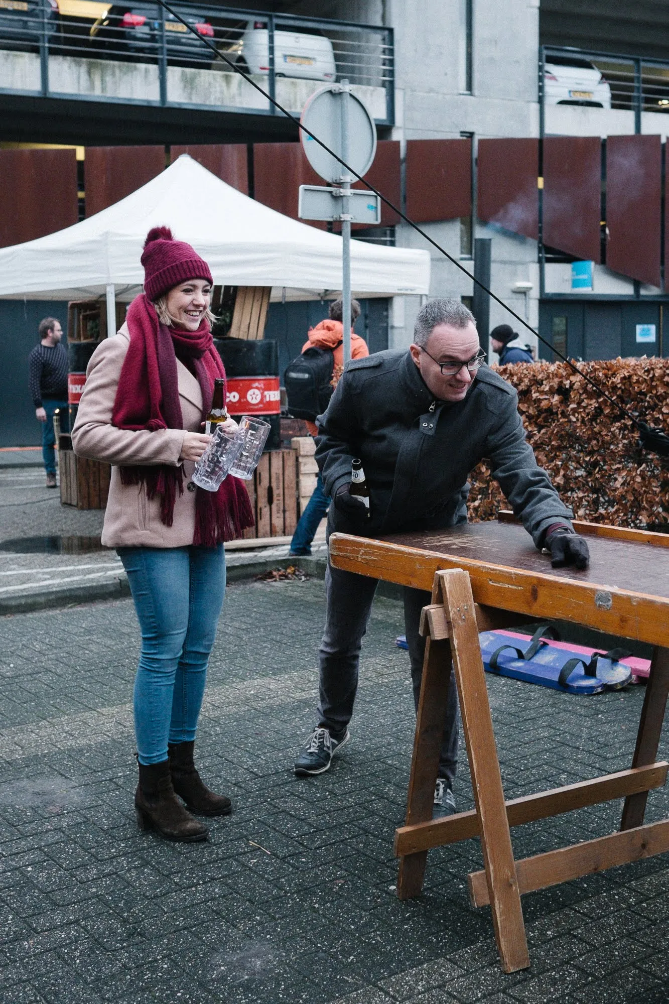 Twee gasten spelen een houten tafelspel buiten tijdens een winterfeest