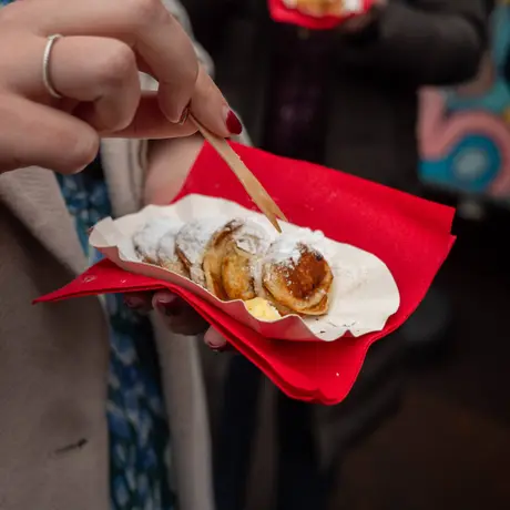 Vers gebakken poffertjes met poedersuiker, uit de hand gegeten op locatie