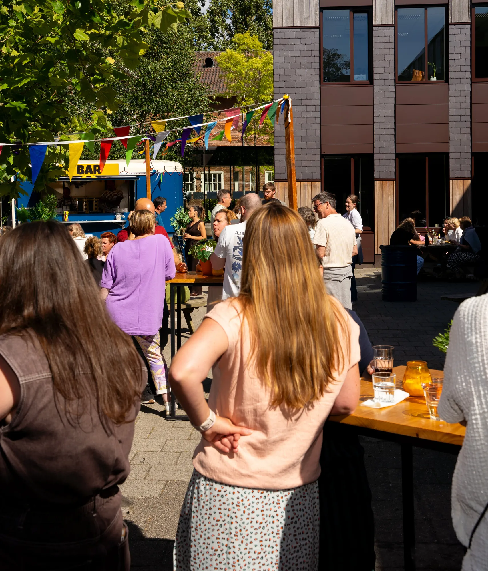Gasten aan statafels bij de bartruck tijdens een volledig verzorgd bedrijfsfeest