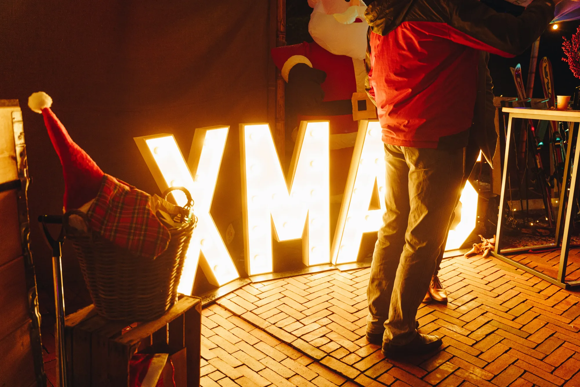 Verlichte XMAS-letters bij de ingang met een gast ervoor