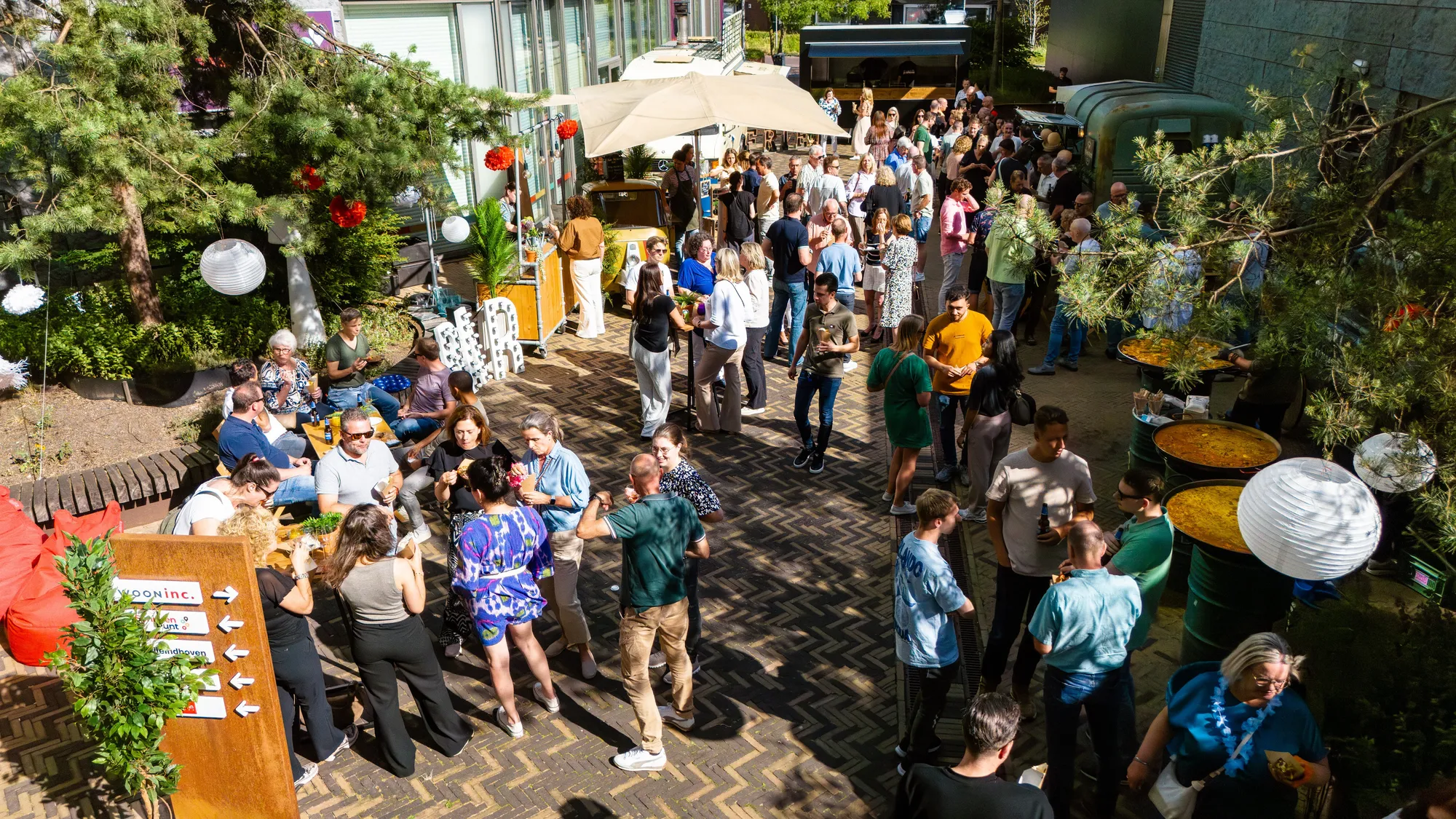 Gasten op een binnenplaats tijdens een zomerse barbecue bij kantoor
