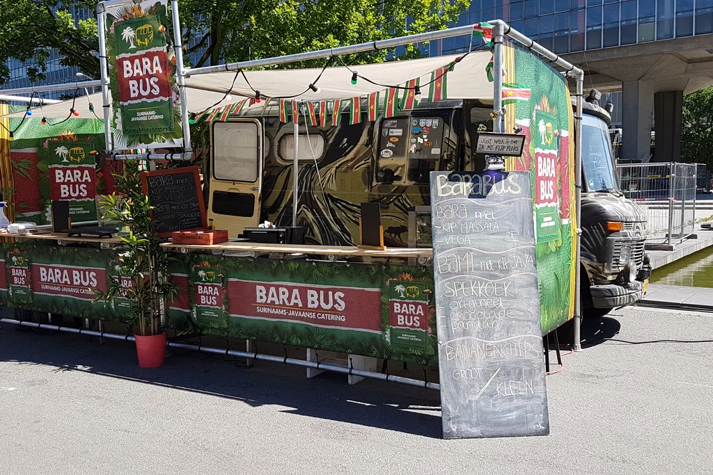 Opgebouwde Bara Bus foodtruck met banners en krijtbord op een zakelijke locatie