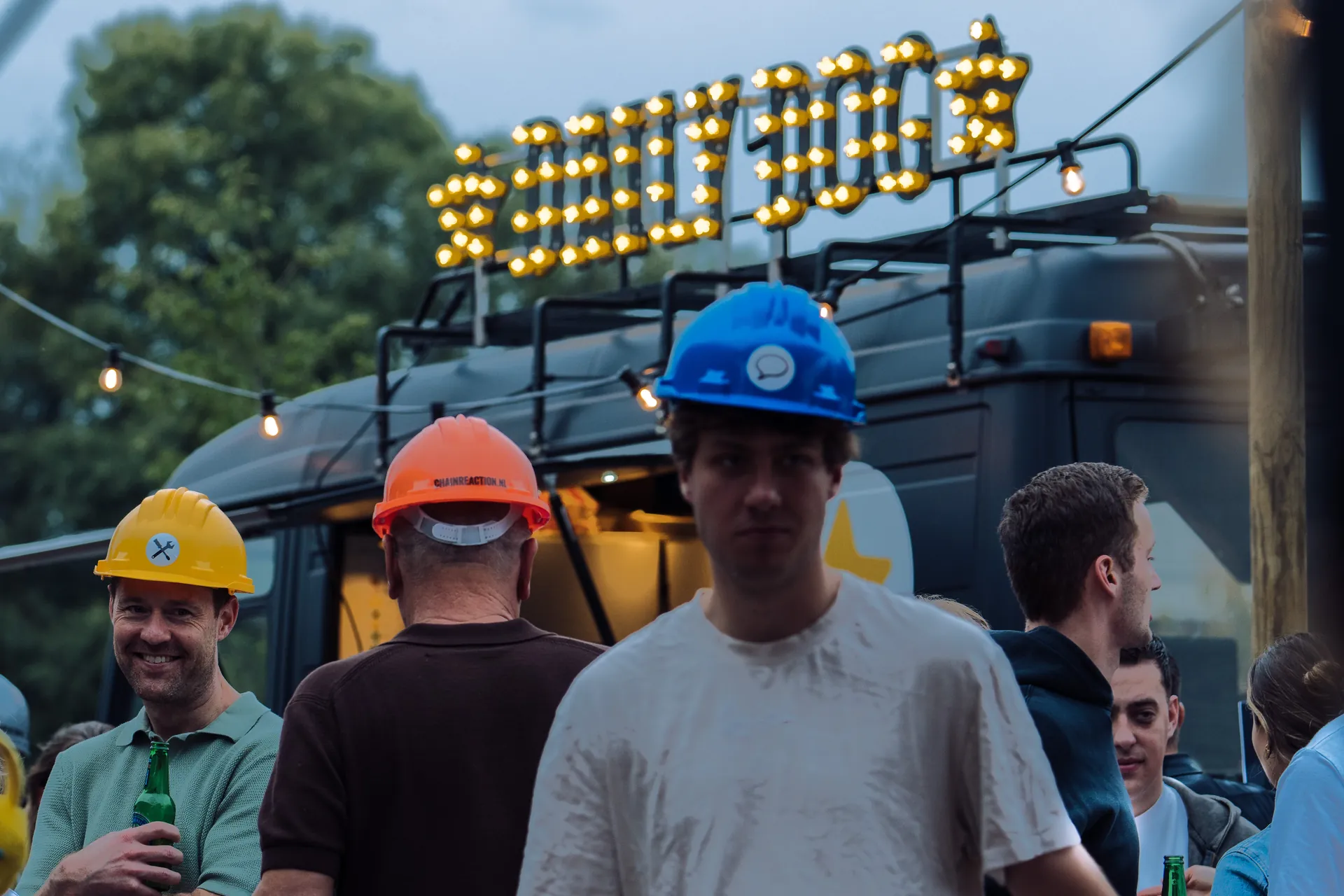 Gasten met gekleurde bouwhelmen voor de Daily Dog foodtruck