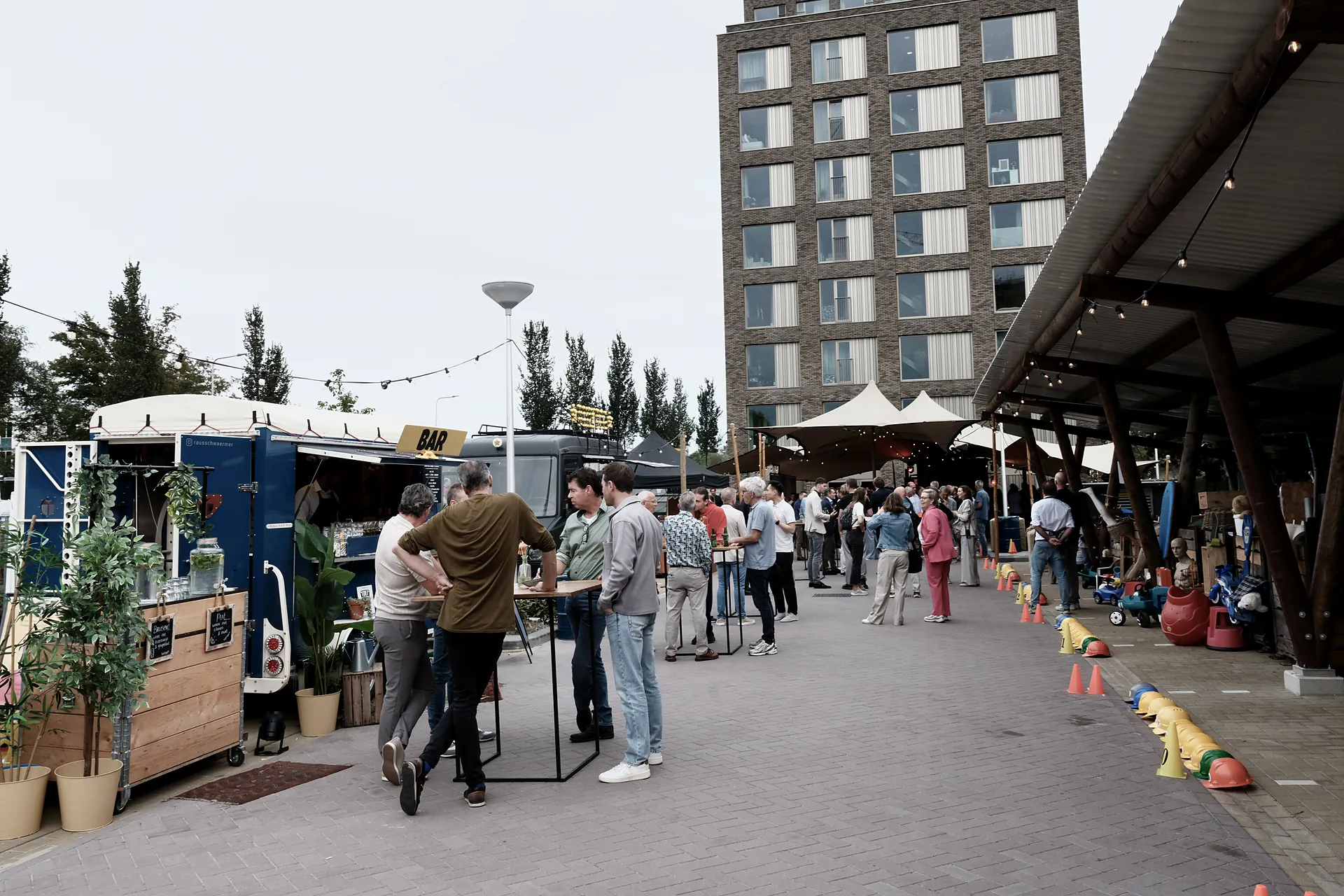 Mobiele bar van Festibar met gasten aan statafels bij een nieuwbouwproject