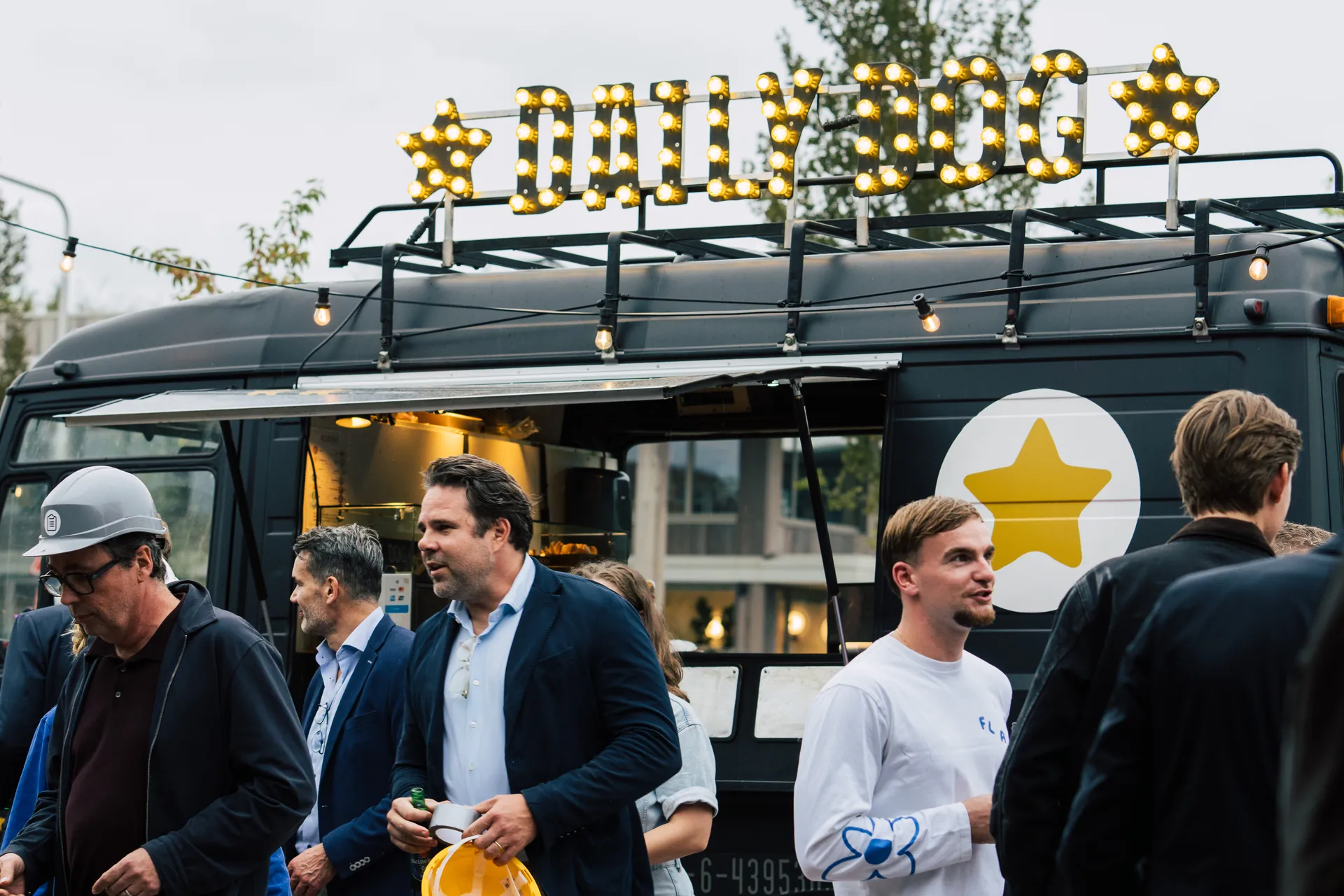 Gasten met bouwhelm bij de Daily Dog hotdog foodtruck