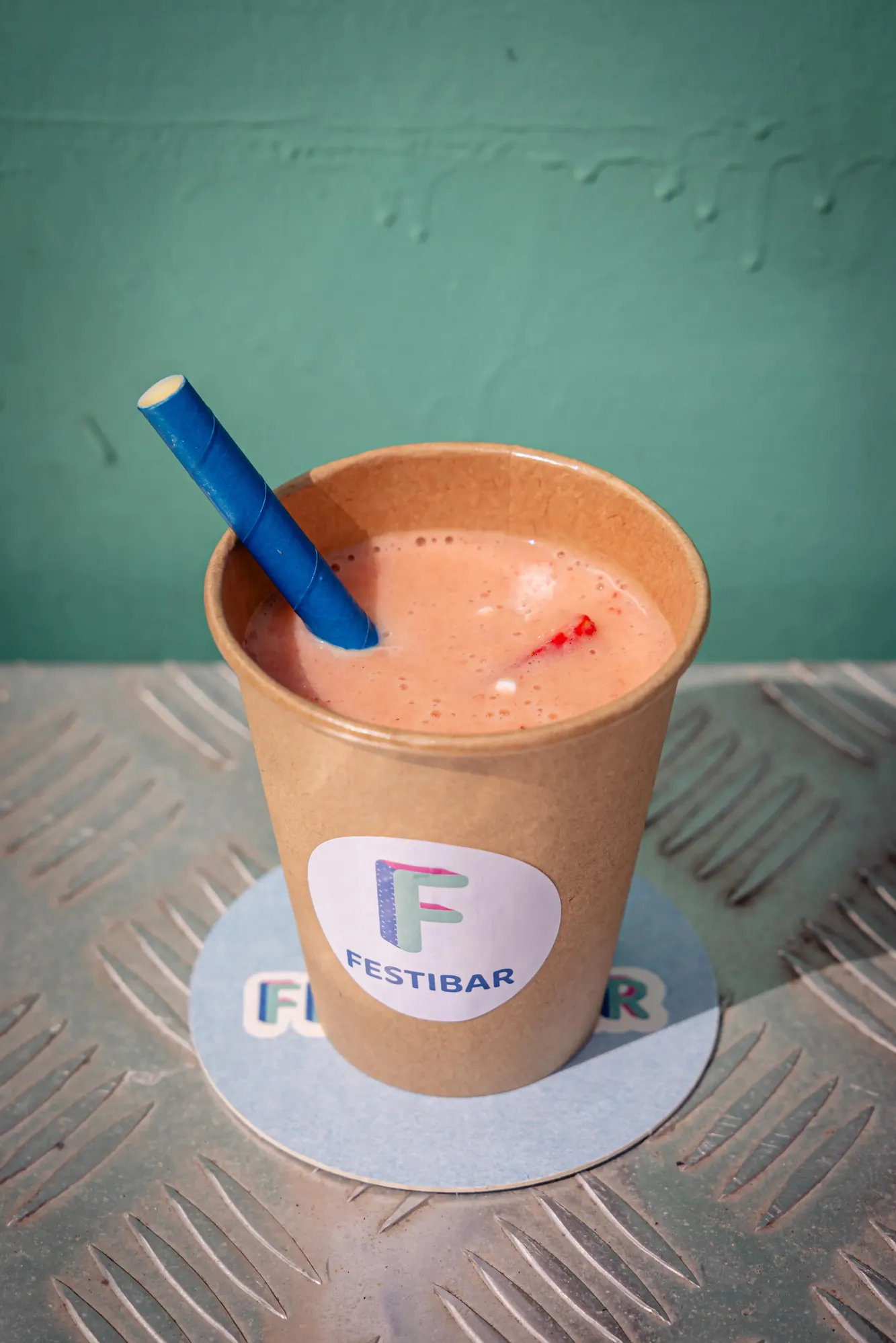 Verse aardbeiensmoothie in een kartonnen Festibar-beker met papieren rietje