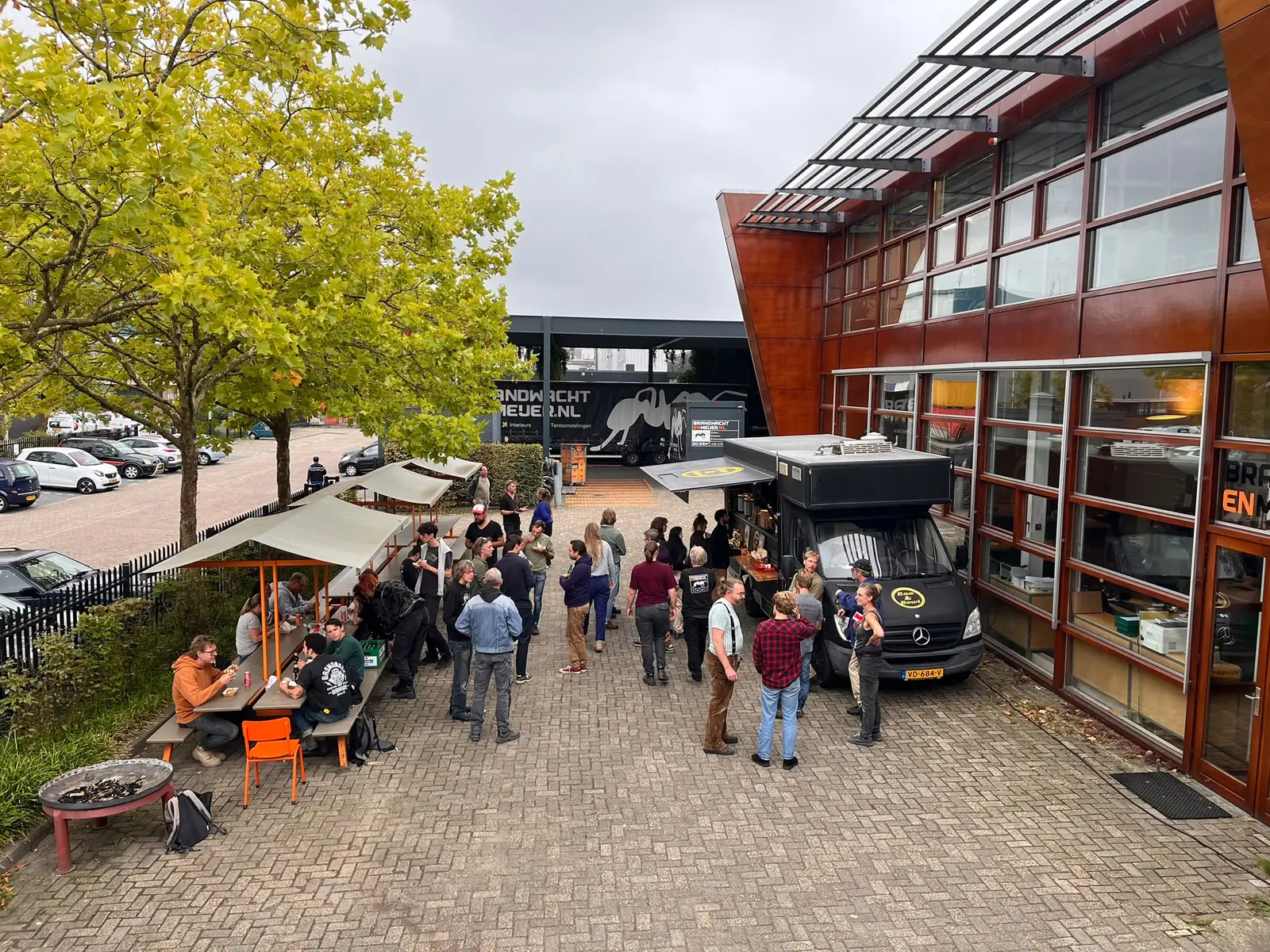 Medewerkers van een productiebedrijf lunchen bij een foodtruck op het eigen bedrijfsterrein