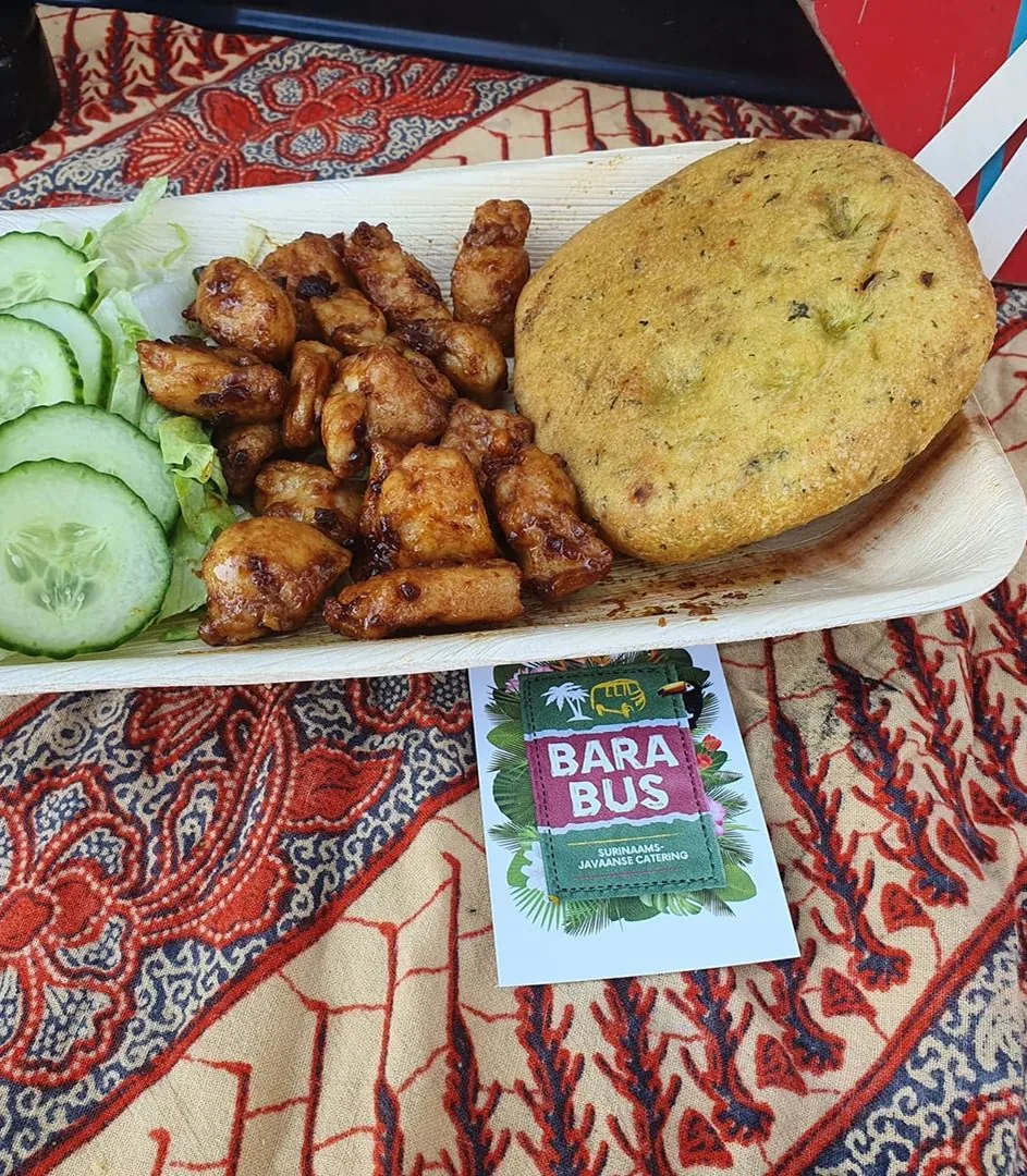 Bara met gegrilde kip, komkommer en salade op een bordje van de Bara Bus